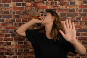 young depressed girl drinking alcohol gesturer stop high quality photo