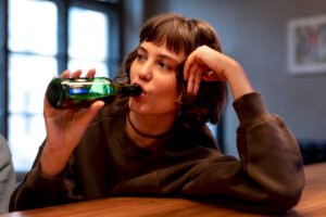 young woman drinking beer alone